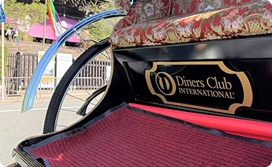 A traditional Japanese rickshaw with red patterned upholstery