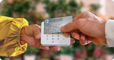 A hand presenting a silver loyalty or payment card to a white mobile card reader held by another hand.