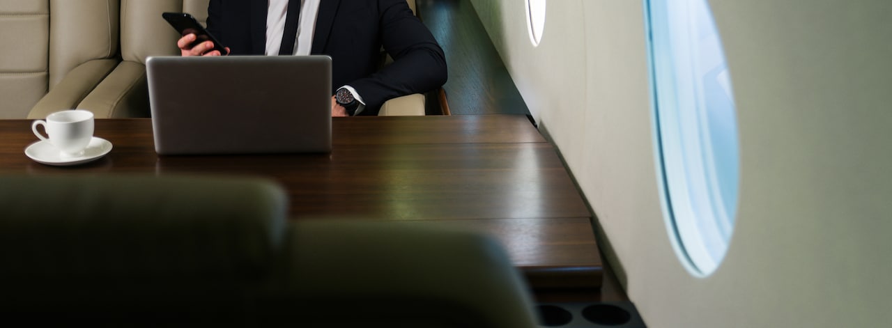 Businessman working on laptop on an airplane