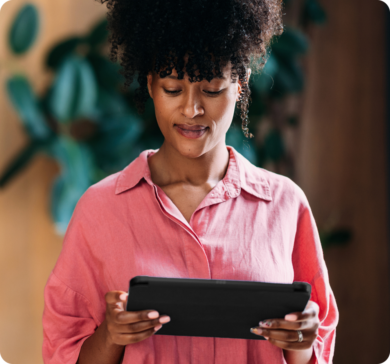 Woman in pink dress holding tablet device