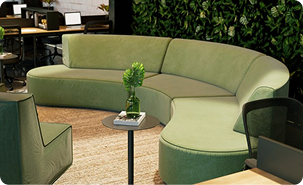 Modern club lounge with curved green sofa seating and small side table.
