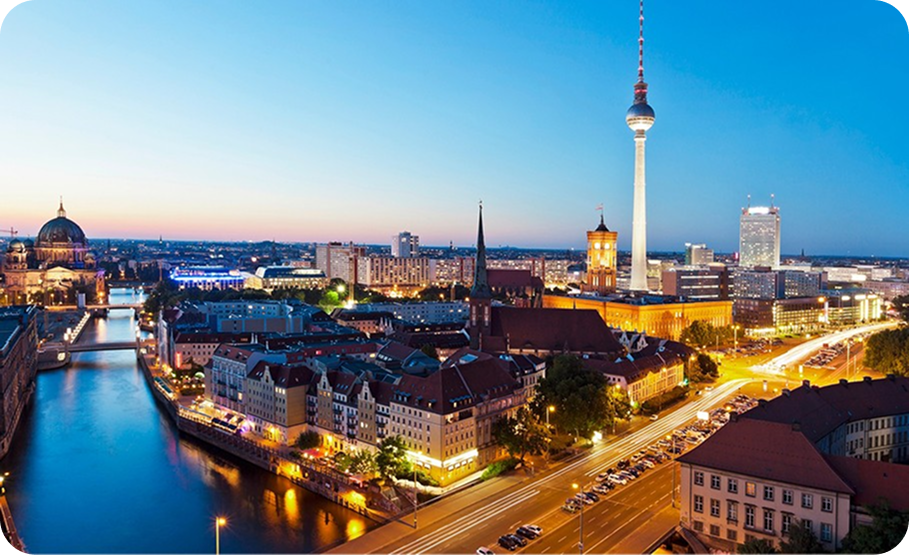 Berlin cityscape with buildings along a river, bridges, and the prominent tower in the distance.