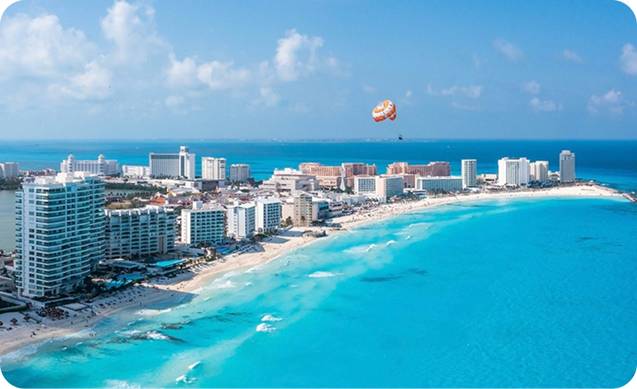 Aerial view of a coastal resort town with a long sandy beach and turquoise ocean.