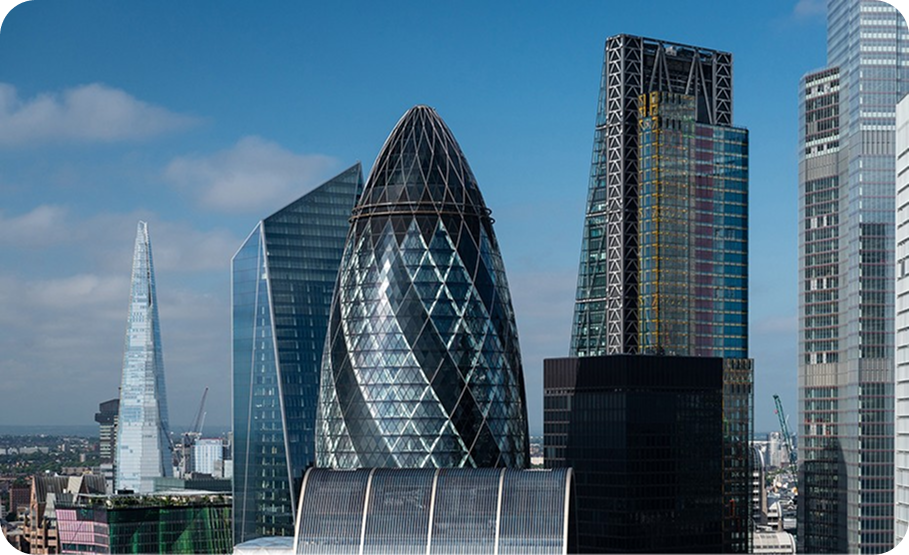 London financial district skyline featuring the Gherkin, the Shard, against a blue sky.