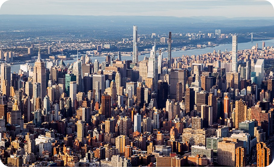 Panoramic view of the New York City skyline from across the water, featuring Manhattan skyscrapers.