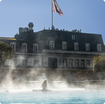 Historic European thermal spa with steam rising in front of a grand building