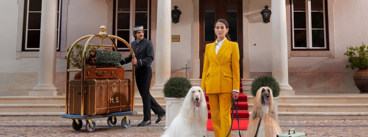 Hotel staff assisting guests with luggage outside a luxury hotel entrance